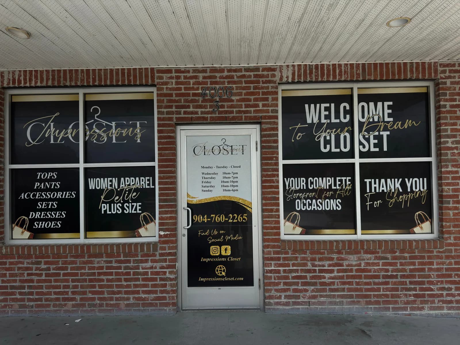 Boutique windows with lettering and store hours